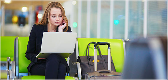 woman in airport working on her laptop